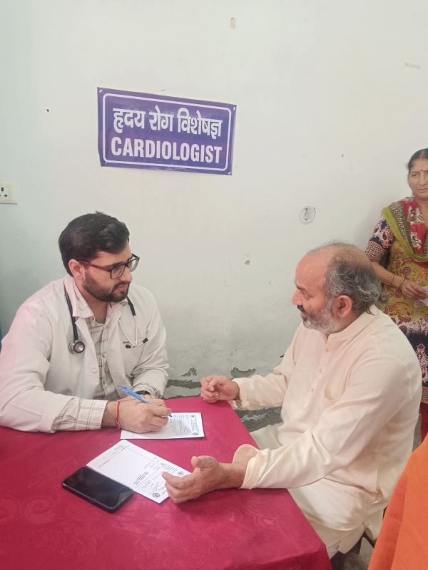 स्वास्थ्य शिविर में चिकित्सक रोगियों का परीक्षण करते।