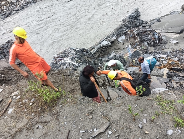 एनडीआरएफ के जवान मणिमहेश तीर्थयात्रियों को निकालते हुए