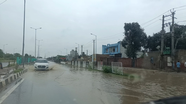 बड़ौदा में नेशनल हाइवे पर जलभराव से गुजरते हुए वाहन।