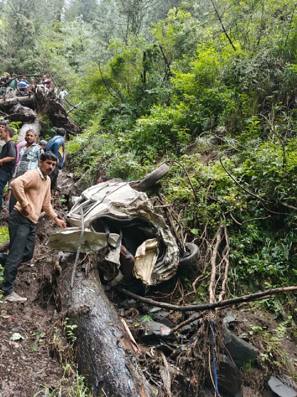 दुर्घटनाग्रस्त वाहन और हादसे के शिकार युवकों को निकालते हुए लोग।