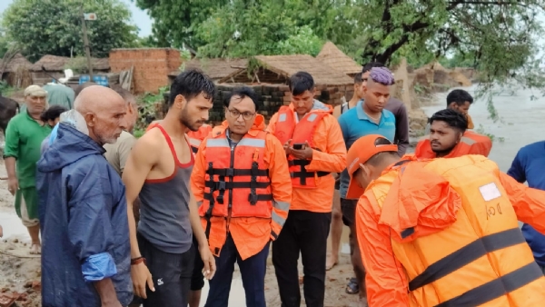बाढ़ में राहत कार्य करते अधिकारी