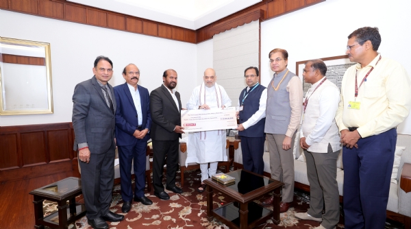 केंद्रीय गृह मंत्री अमित शाह को चेक सौंपते रेप्को बैंक के अध्यक्ष ई. संथानम