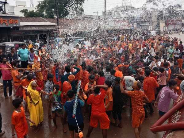 पुराना बस स्टैंड के पास कृत्रिम वर्षा में झूमते हुए श्रध्दालु।