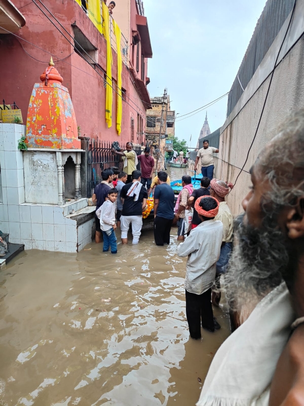 शव दाह के लिए गलियो में नाव से जाते लोग