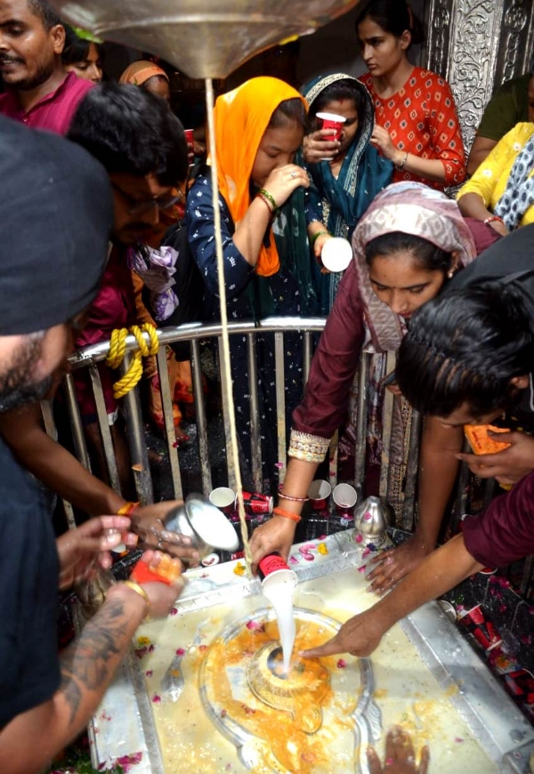 कानपुर में बाबा आनंदेश्वर मंदिर में सावन के चौथे सोमवार पर जलाभिषेक करते श्रद्धालुओं का छायाचित्र