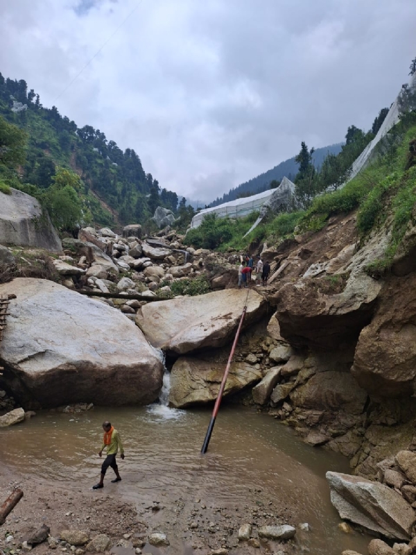 रसियों से खेंचकर बिजली के पोल ले जाते हुए।