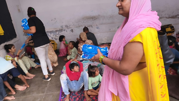 बाढ़ पीड़ितों में सेनेटरी किट वितरित एक्युरा क्रिटिकल केयर अस्पताल के कर्मचारी का छाया चित्र