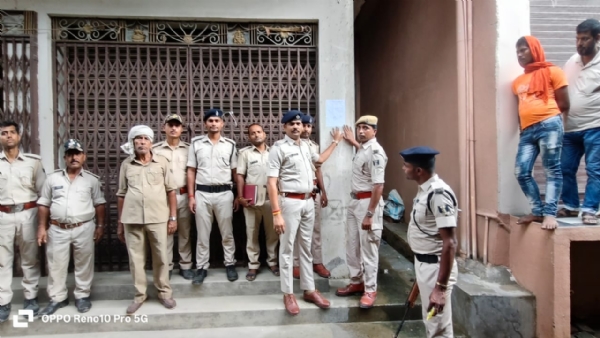 इश्तेहार चिपकाते पुलिस के अधिकारी