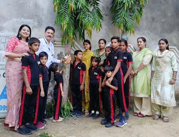 गुरुग्राम के गांव गढ़ी-हरसरू में पेड़ों को राखी बांधते बच्चे व बड़े।