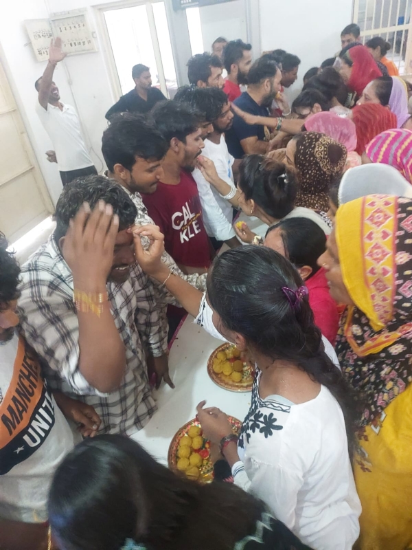 जिला कारागार में बिना किसी दीवार के भाइयों को एकसाथ राखी बांधते हुए बहनें।