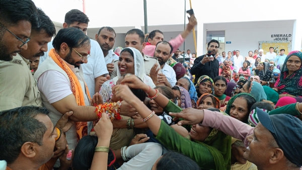 विधायक देवेंद्र चतरभुज अत्री के दोनों हाथों पर राखी बांधते हुए महिलाएं।