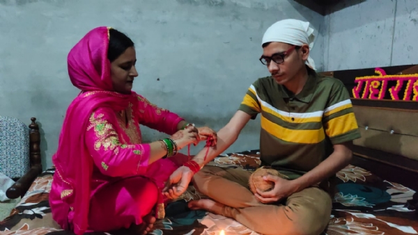 भाई को राखी बांधते हुए बहन।