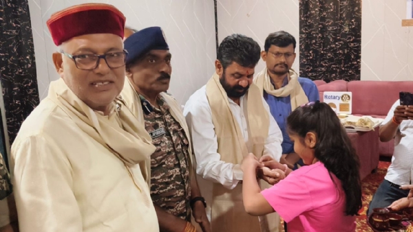 राज्यमंत्री को राखी बांधती बच्ची