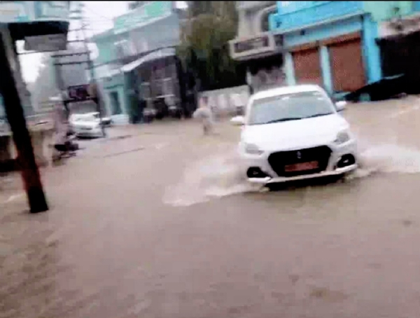पानीपत में बारिश से हुए जलभराव के बीच गुजरते वाहन।