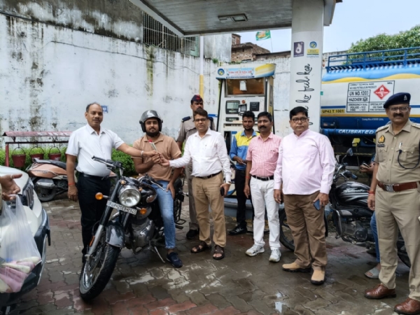 बरेली में “नो हेलमेट, नो फ्यूल” अभियान के दौरान हेलमेट लगाकर पेट्रोल भरवाने पहुंचे चालक को पुष्प भेंट कर सम्मानित करते परिवहन और पुलिस विभाग के अधिकारी।