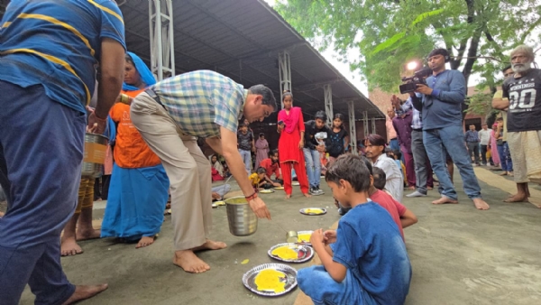 खाना पराेसते हुए जिलाधिकारी सीपी सिंह