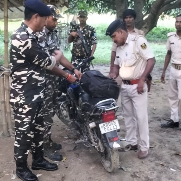 बरामद बाइक पर लदी गांजा का निरीक्षण करते पुलिसकर्मी