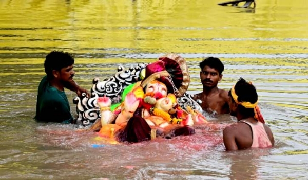 कानपुर में गंगा बैराज पर बने कृत्रिम तालाब में भगवान गणेश को विसर्जित करते का छायाचित्र