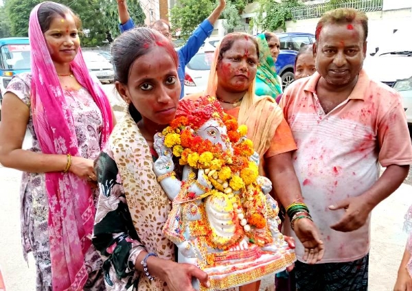 कानपुर में परमट घाट पर बने कृत्रिम तालाब में भगवान गणेश को विसर्जन के लिए जाती महिलाएं का छायाचित्र