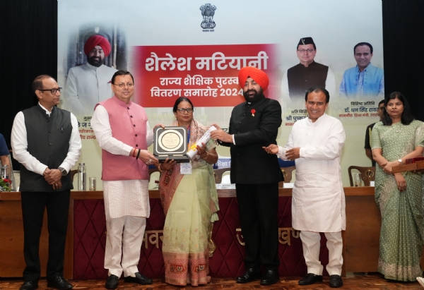 सम्मान समारोह में पुरस्कार लेती एक शिक्षिका।