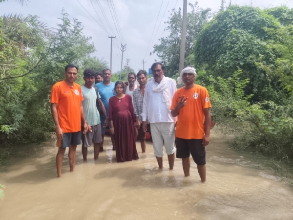 गर्भवती महिला का रेस्क्यू कर उसे सुरक्षित स्थान पर ले जाते प्रशासनिक कर्मचारी
