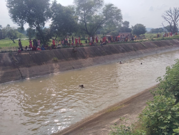 मुडपेली गाँव स्थित बाण सागर नहर में डूबे बालक को खोजते ग्रामीण