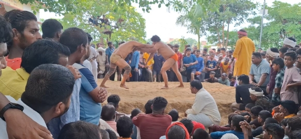 कुश्ती प्रतियोगिता में जोर अजमाइश करते पहलवान।