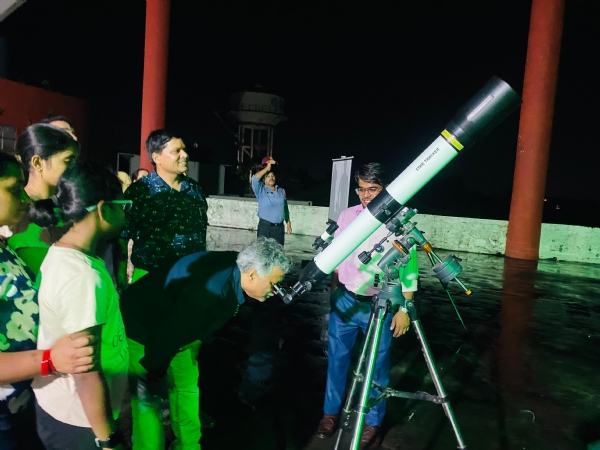 उत टेलिस्कोप के माध्यम से ग्रहण का अवलोकन करते।