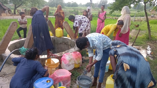 भैसौढ बलाय पहाड़ ग्राम सभा के पश्चिम टोला कोलान बस्ती में कुएं का पानी निकालकर कर कपड़े से छानते ग्रामीण