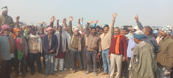 खेतों में खड़े होकर प्रदर्शन करते किसान।