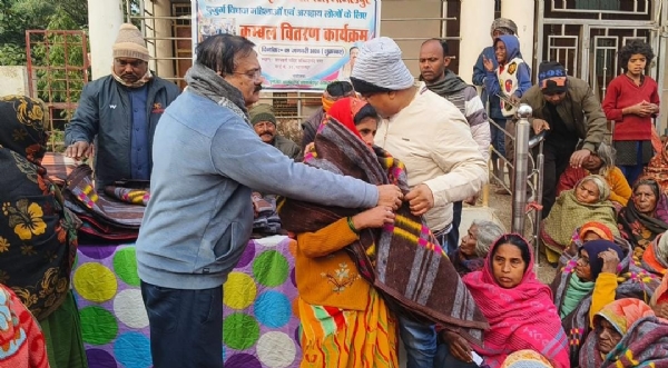 कंबल बांटते लोग