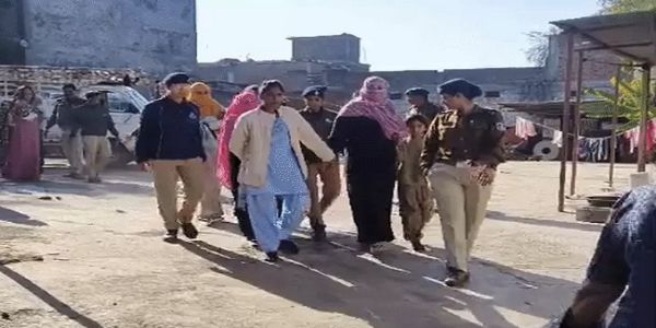 छापामार कार्रवाई के बाद आरोपियों को मकान से बाहर लाते हुए पुलिस