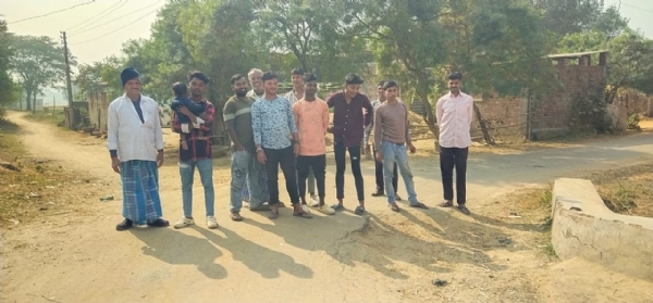 धंसी हुई सड़क दिखाते ग्रामीण