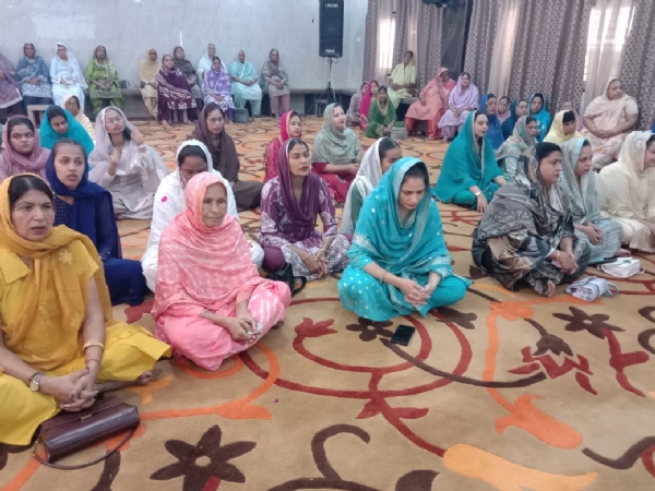 गुरूद्वारे में संगतकारों का कीर्तन सुनती हुई समाज की महिलाएं।