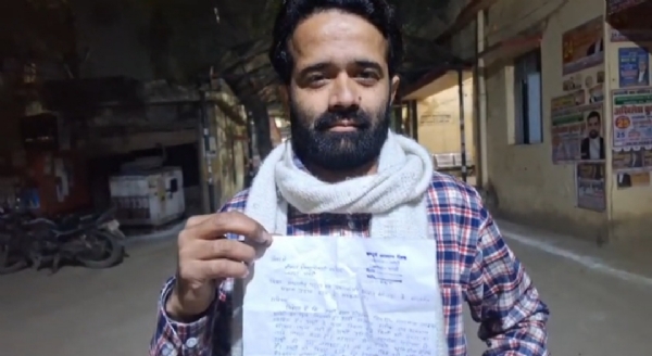 प्रार्थना पत्र लिए खड़ा युवक प्रार्थना पत्र लिए खड़ा युवक