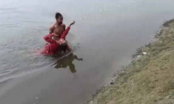 महिला को यमुना नदी से निकालता साहसी युवक