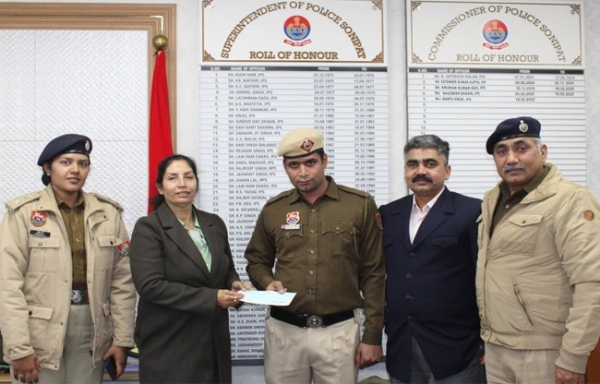 सोनीपत: आयुक्त ममता सिंह सिपाही संजय रमन         को उपचार सहायता का चेक देते हुए