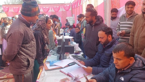 शिविर में स्वास्थ्य जांच के लिए लाइन में खड़े लोग।