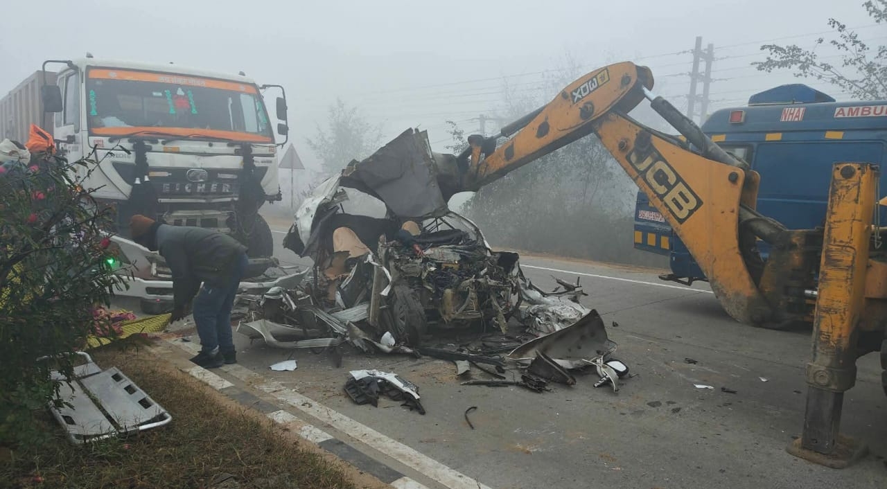 दुर्घटना ग्रस्त वाहन को हटाता बुलडोजर