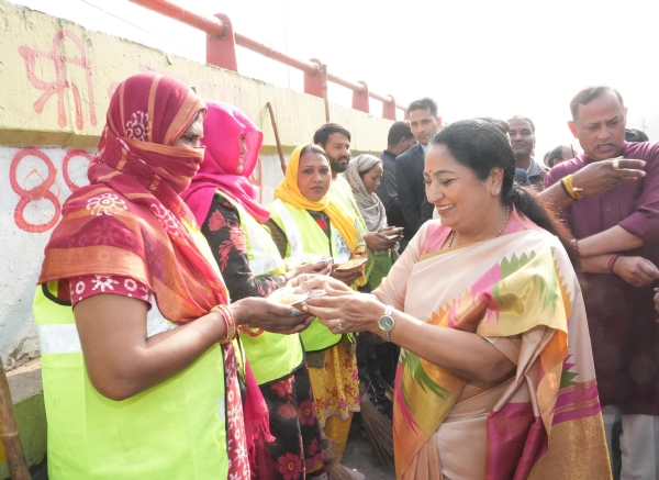 मुख्यमंत्री रेखा गुप्ता मरघट वाले हनुमान मंदिर के पास सफाई कर्मचारियों को प्रसाद देते हुए।
