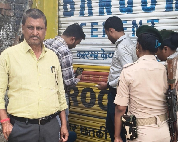 गोदाम को सील करते अधिकारी गोदाम को सील करते अधिकारी