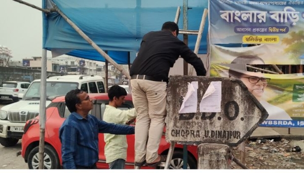 सरकारी जगहों से पोस्टर-बैनर हटाते प्रशासनिक अधिकारी