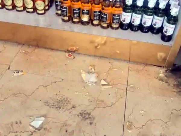 ठेके पर फायरिंग के बाद टूटी बोतल के टुकड़े