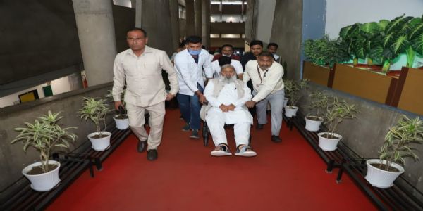 हरियाणा के परिवहन मंत्री अनिल विज व्हील चेयर पर वाेट डालने के लिए आते हुए