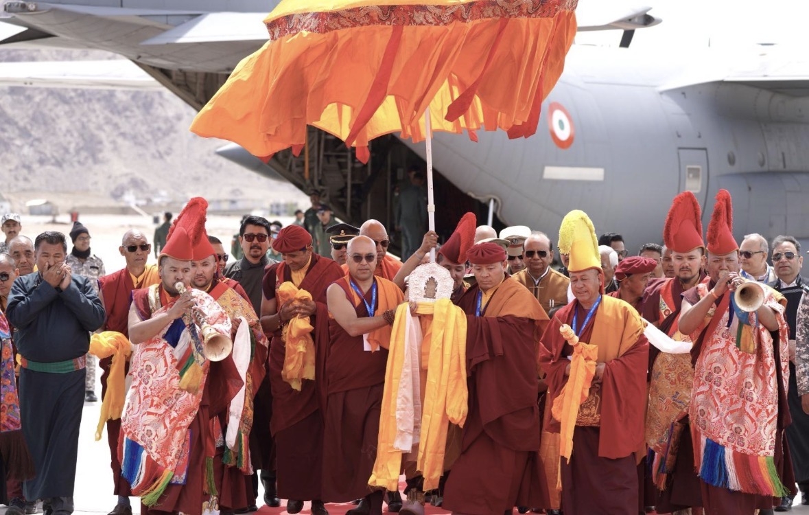 लेह एयरपोर्ट पर विमान से उतारे जाते भगवान बुद्ध के पवित्र अवशेष, पारंपरिक विधि से स्वागत के दौरान मौजूद धर्मगुरु और अधिकारी।