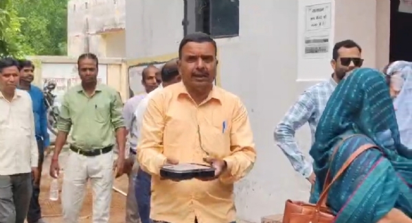 गुणवत्ता विहीन भोजन को दिखाते शिक्षक