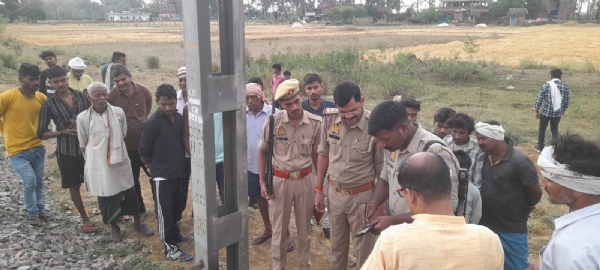 धनसीरिया गांव के रेलवे लाइन  बिजली के खंभे के पास मिले शव को देखते ग्रामीण व पुलिस।