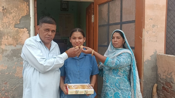 योगिता का मुंह मीठा करवाते हुए पिता बलवान श्योकंद,  माता कविता देवी।