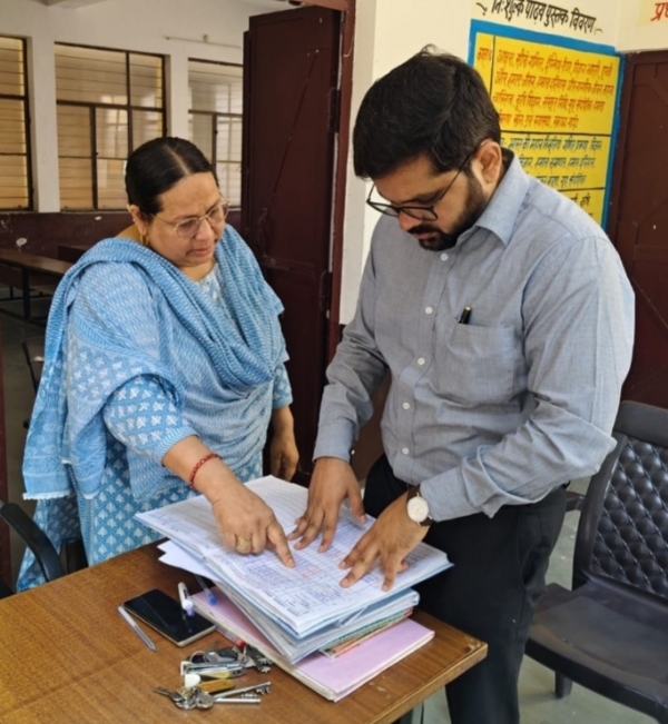 रजिस्टर का अवलोकन करते जिलाधिकारी