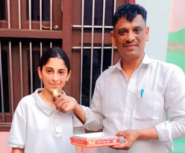 बेटी मंजू को मिठाई खिलाते पिता वीरेन्द्र।